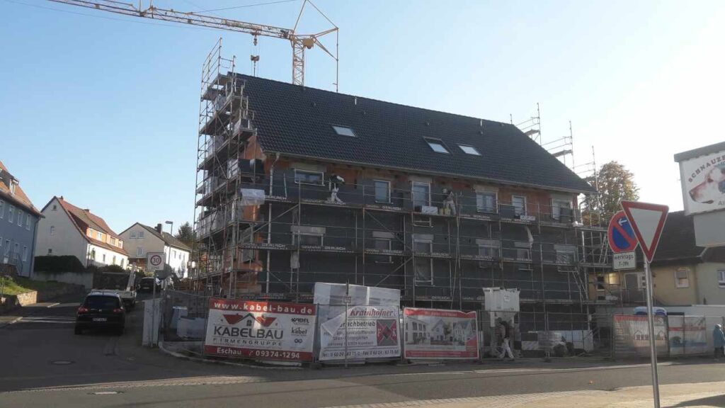 Gerüstetes Ziegelhaus mit fertig gedecktem Satteldach.