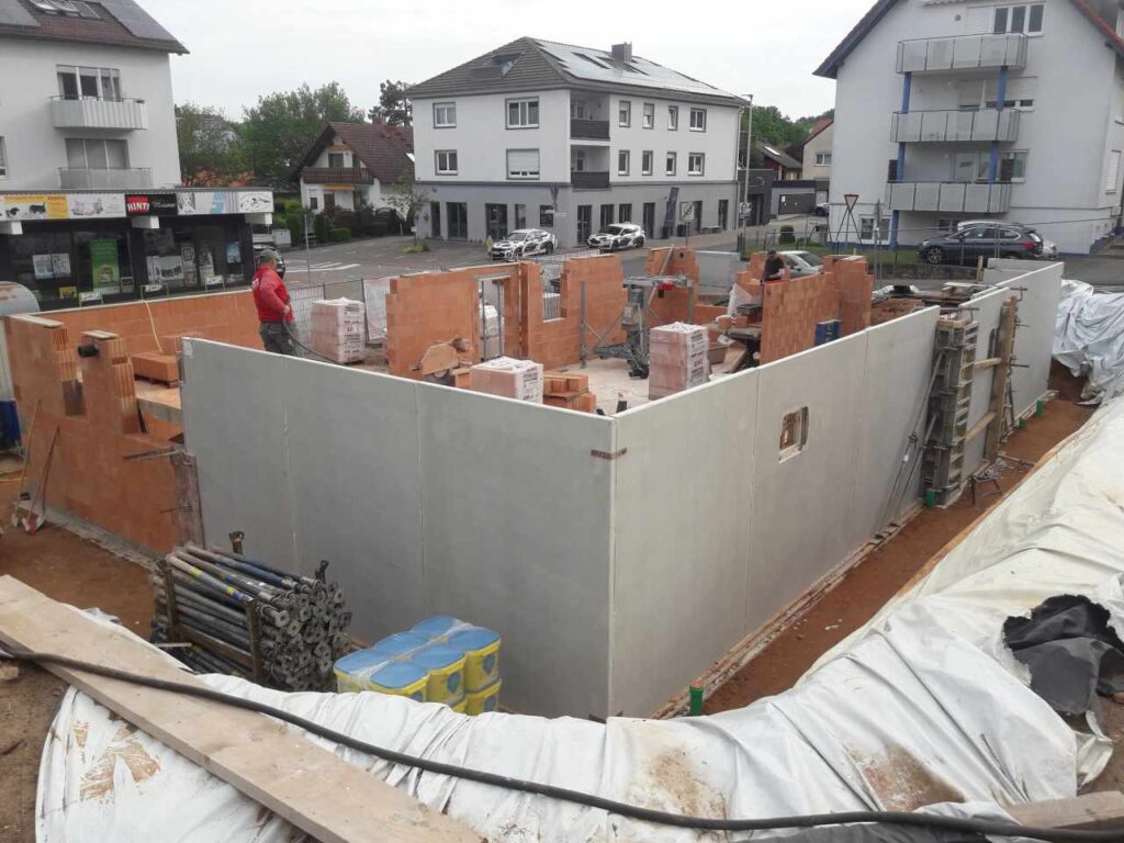 Kelleraußenwände im Rohbau, Bereich teilweise mit Planen abgedeckt.
