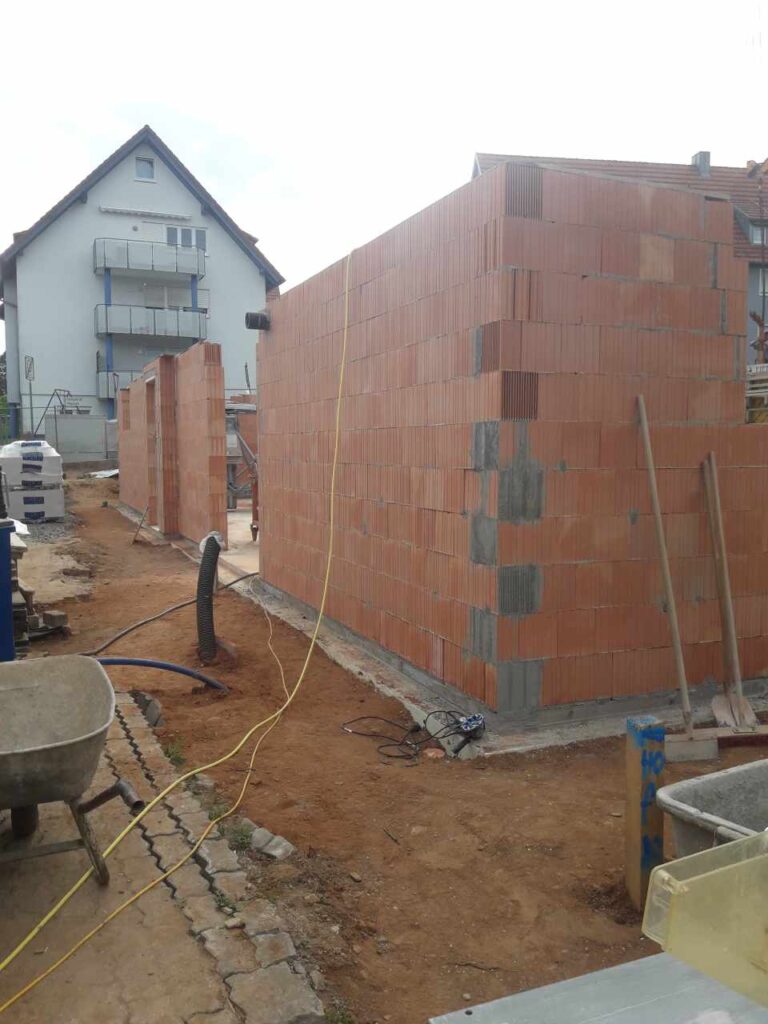 Aufgehendes Ziegelmauerwerk im Erdgeschoss, Baustelle im Wohngebiet.