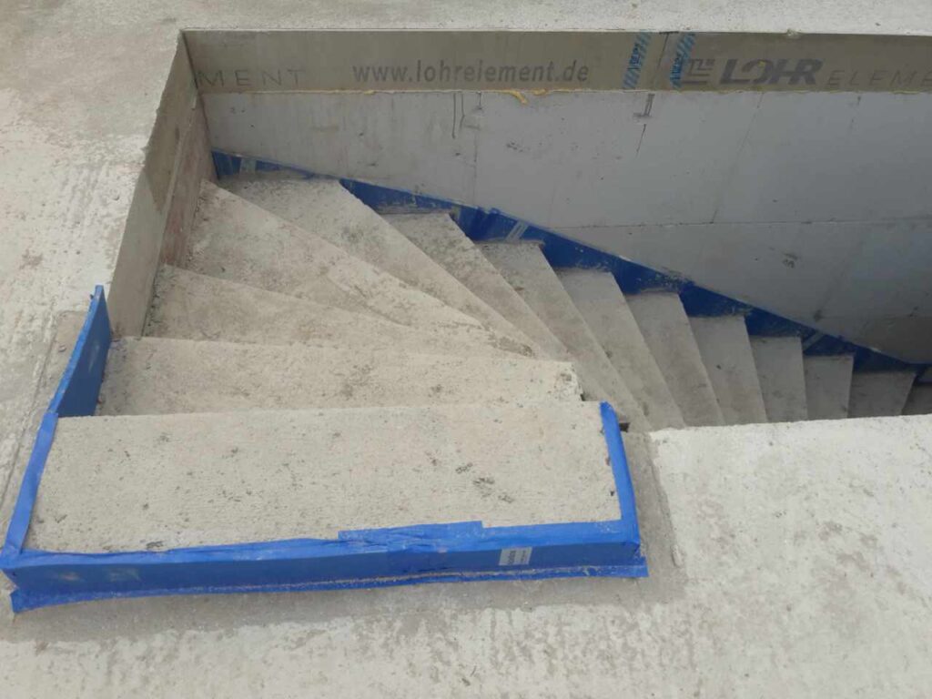 Treppenantritt mit Fuge und Schutzband im Rohbau.