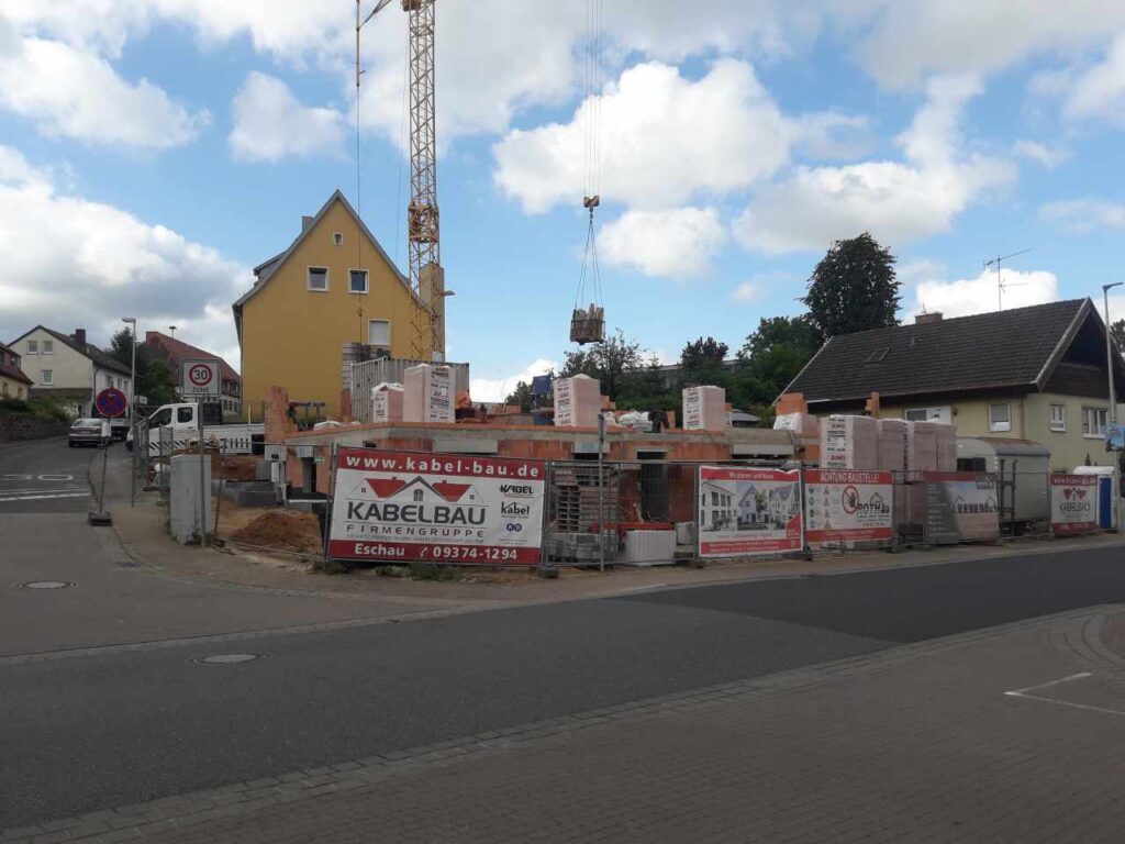 Kran, Absperrungen und Baustellenschild an der Zufahrt.